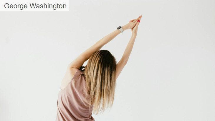 Back view of anonymous young female in active top stretching rib cage with raised arms during workout