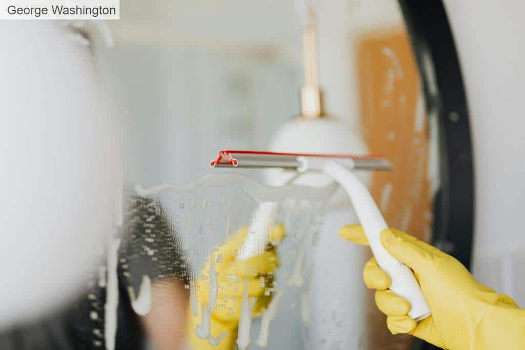 Faceless person removing water from mirror